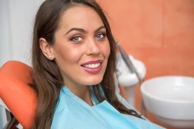 patient smiling at her follow-up after getting oral surgery at Derek H. Tang, DDS