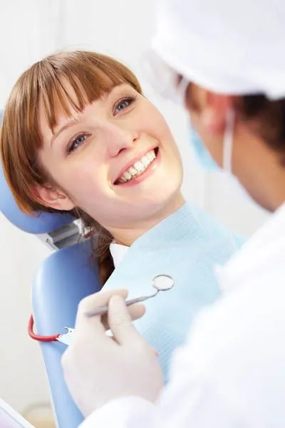 patient smiling while she lays in the dental chair at Derek H. Tang, DDS