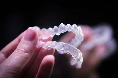 person holding clear aligners
